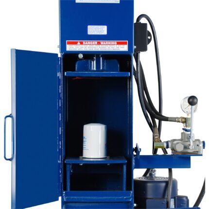 Close-up of a blue industrial oil filter crusher with the door open, showing a white spin-on filter positioned inside the crushing chamber. Hydraulic hoses, gauge, and control lever are visible on the right side of the machine