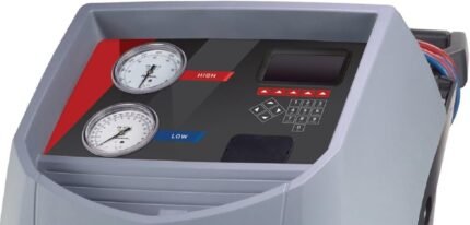Close-up view of a Robinair A/C recovery machine control panel featuring high and low pressure gauges, keypad controls, and a digital display for precise automotive HVAC diagnostics