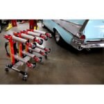 Ranger GoCart wheel dollies neatly stored on the rolling stand beside a classic car, showcasing their compact, space-saving design and rugged build for automotive shops and garages