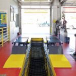 BendPak P-9000LT 9,000-lb. low-rise pit lift with open-center design for full undercarriage and wheel service access.