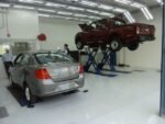 Heavy-duty steel lift platforms with rubber pads protecting vehicle frames
