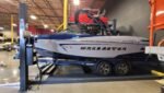 Wrenchers HD-75BXT 7,500-lb. four-post lift providing high-clearance parking and secure boat storage solution.