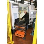 Technician using the Beta Tools C27S-O folding tool trolley beside industrial equipment, demonstrating its portability and easy tool access. Get it at Wrenchers.com.