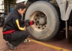 Mechanic using a Chicago Pneumatic 7782-6 heavy-duty impact wrench to remove lug nuts from a truck wheel inside a service bay – Get it at Wrenchers.com today