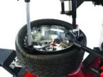 Top view of the Coats APX-90 tire changer using RoboArm assist for controlled mounting on low-profile and performance wheels. Designed for fast, damage-free professional tire service