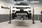 Front-facing Range Rover lifted on MaxJax M7K portable two-post lift.
