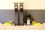 MaxJax portable car lift system stored compactly against garage wall.
