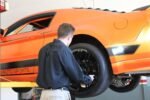 Ford Mustang elevated on MaxJax M6 portable two-post garage lift.