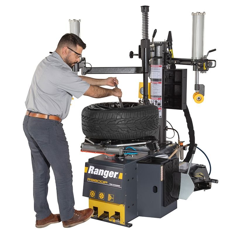 R980DP Tire Changer Technician using the R980DP bead lifting tool for precise demounting of stiff sidewall tires. Built to reduce effort while protecting wheels during service. SKU 5140174.