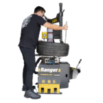Technician operating the Ranger R980XR tire changer, demonstrating ergonomic tire handling and efficient demounting workflow